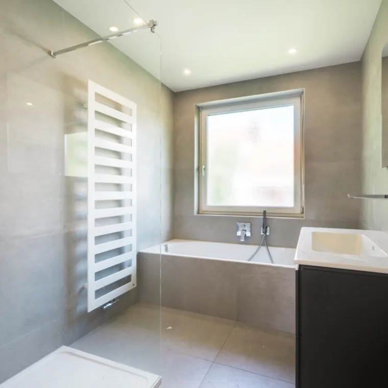 Modernisiertes Bad in Großformatfliesen mit Badewanne und Regendusche, München-Untergiesing — Immobilienfotografie Maximilian Sydow