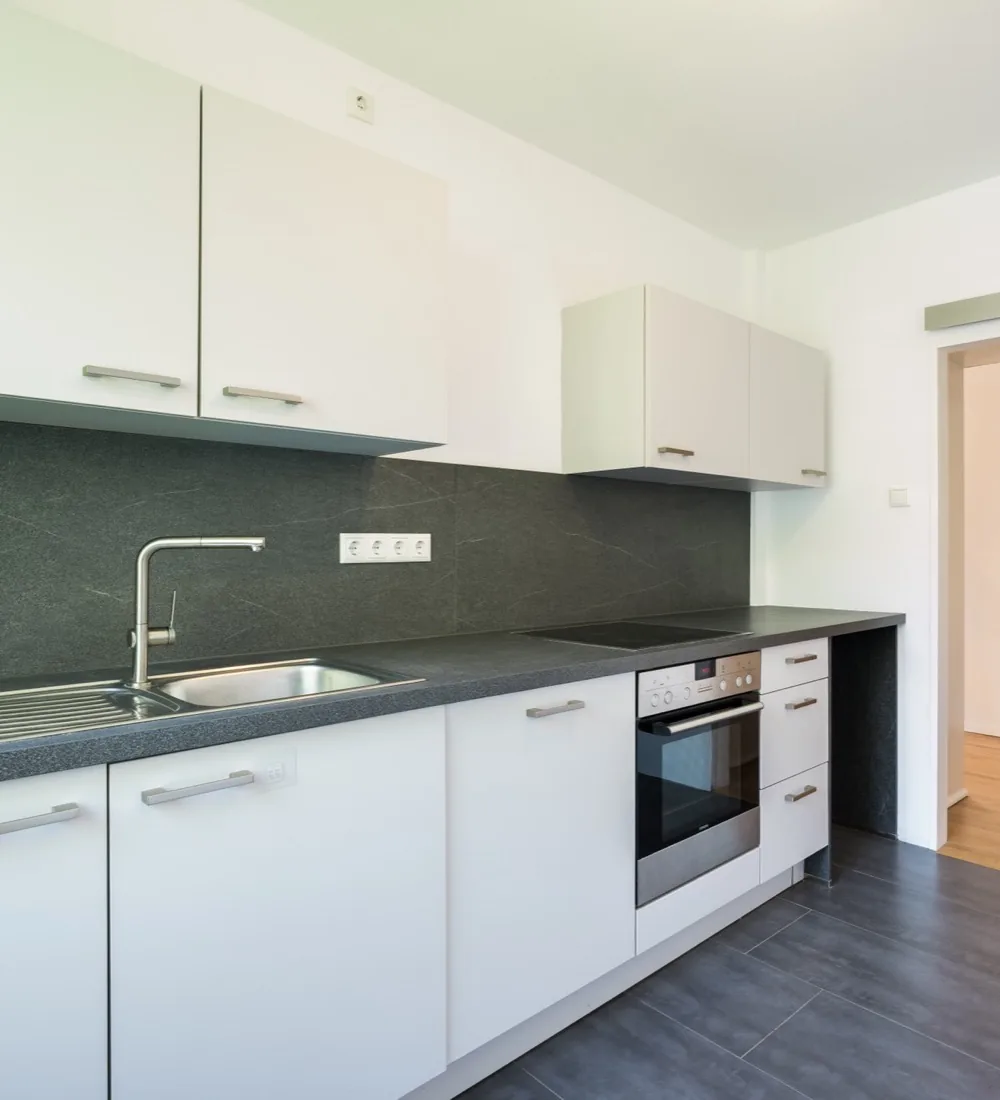 Architekturfotografie München: Einbauküche mit dunkler Arbeitsplatte in einer Mietwohnung