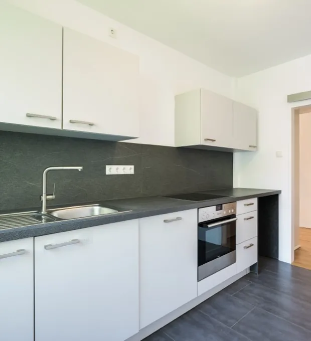 Einbauküche mit dunkler Arbeitsplatte in einer Münchner Mietwohnung — Immobilienfotografie Maximilian Sydow